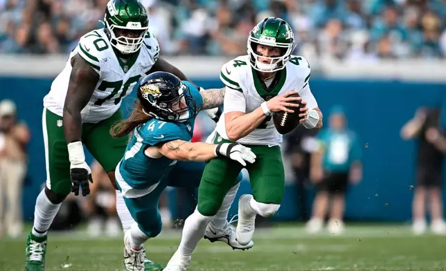Jacksonville Jaguars linebacker Dennis Gardeck (47) sacks New York Jets quarterback Brady Cook (4) during the second half of an NFL football game, Sunday, Dec. 14, 2025, in Jacksonville, Fla. (AP Photo/Phelan M. Ebenhack)
