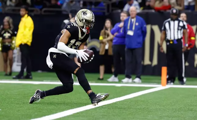 New Orleans Saints wide receiver Chris Olave (12) scores a touchdown in the second half of an NFL football game against the Carolina Panthers, Sunday, Dec. 14, 2025, in New Orleans. (AP Photo/Butch Dill)