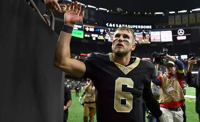 New Orleans Saints quarterback Tyler Shough (6) high fives fans as he leaves the field after an NFL football game against the Carolina Panthers, Sunday, Dec. 14, 2025, in New Orleans. (AP Photo/Ella Hall)