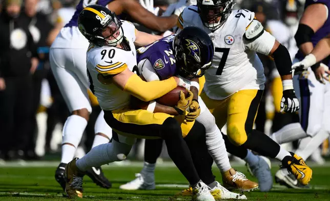 Pittsburgh Steelers linebacker T.J. Watt (90) tackles Baltimore Ravens running back Derrick Henry (22) during the first half of an NFL football game, Sunday, Dec. 7, 2025, in Baltimore. (AP Photo/Nick Wass)