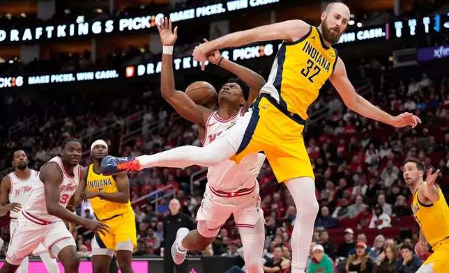 Indiana Pacers center Jay Huff (32) fouls Houston Rockets guard Amen Thompson, left, under the basket during the first half of an NBA basketball game Monday, Dec. 29, 2025, in Houston. (AP Photo/Karen Warren)