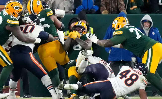 Green Bay Packers running back Josh Jacobs (8) scores a touchdown against the Chicago Bears during the second half of an NFL football game Sunday, Dec. 7, 2025, in Green Bay, Wis. (AP Photo/Morry Gash)