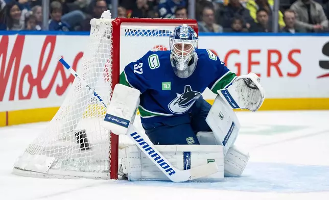 Vancouver Canucks' goaltender Kevin Lankinen (32) watches during the second period of an NHL hockey game against the Utah Mammoth in Vancouver, on Friday, Dec. 5, 2025. (Ethan Cairns/The Canadian Press via AP)