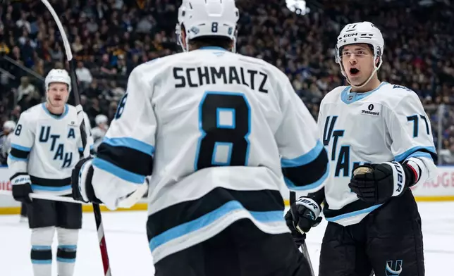Utah Mammoth's JJ Peterka (77) celebrates after a goal by teammate Nick Schmaltz (8) against the Vancouver Canucks during the second period of an NHL hockey game in Vancouver, British Columbia, Friday, Dec. 5, 2025. (Ethan Cairns/The Canadian Press via AP)