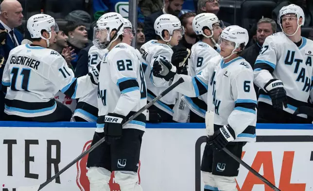 Utah Mammoth's Kevin Stenlund (82) celebrates with teammates after his goal against the Vancouver Canucks during the third period of an NHL hockey game in Vancouver, British Columbia, Friday, Dec. 5, 2025. (Ethan Cairns/The Canadian Press via AP)