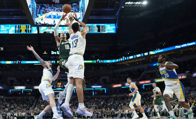 Milwaukee Bucks forward Kyle Kuzma (18) shoots over Indiana Pacers center Tony Bradley (13) during the second half of an NBA basketball game in Indianapolis, Tuesday, Dec. 23, 2025. (AP Photo/AJ Mast)