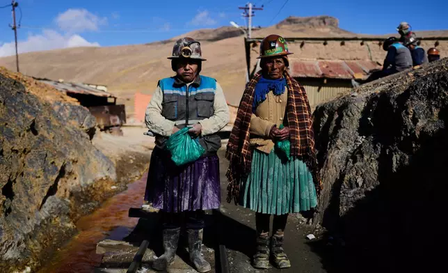 Miners Macaria Alejandro, left, and Julia Zenteno pose for a photo before starting work at the El Porvenir mine in Japo, Bolivia, Tuesday, Sept. 16, 2025. (AP Photo/Juan Karita)
