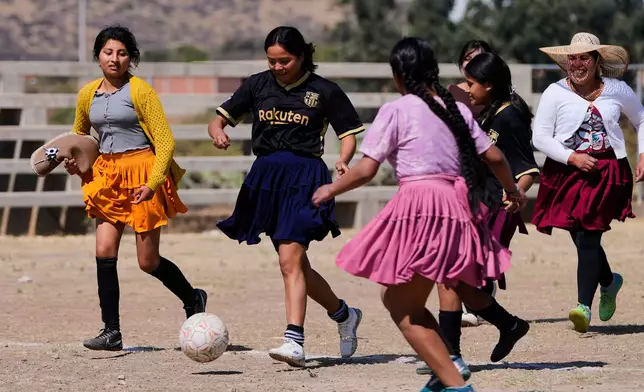 Players chase the ball during a friendly soccer match in Cotapachi, Bolivia, Sunday, Sept. 14, 2025. (AP Photo/Juan Karita)