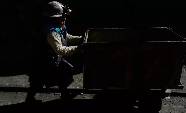 Miner Macaria Alejandro pushes a cart at the Porvenir mine in Japo, Oruro, Bolivia, Tuesday, Sept. 16, 2025. (AP Photo/Juan Karita)