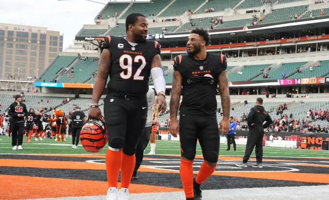 Cincinnati Bengals defensive tackle B.J. Hill (92) leaves the field with safety Geno Stone, right, after an NFL football game against the Arizona Cardinals, Sunday, Dec. 28, 2025, in Cincinnati. (AP Photo/Jeff Dean)