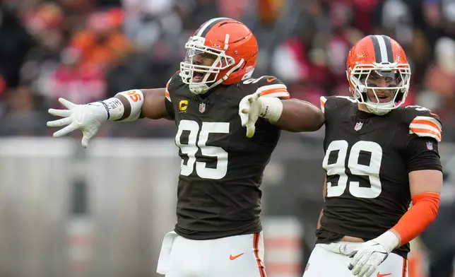 Cleveland Browns defensive end Myles Garrett (95) celebrates after sacking San Francisco 49ers quarterback Brock Purdy with defensive end Cameron Thomas (99) during the second half of an NFL football game, Sunday, Nov. 30, 2025, in Cleveland. (AP Photo/Sue Ogrocki)