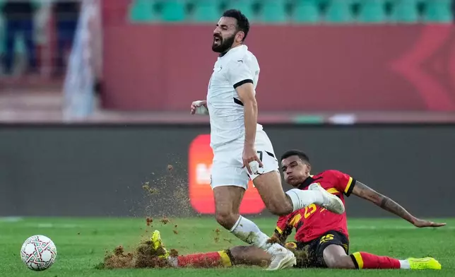 Egypt's Mohanad Lasheen is challenged by Angola's Randy Nteka during the Africa Cup of Nations group B soccer match between Angola and Egypt in Agadir, Morocco, Monday, Dec. 29, 2025. (AP Photo/Mosa'ab Elshamy)