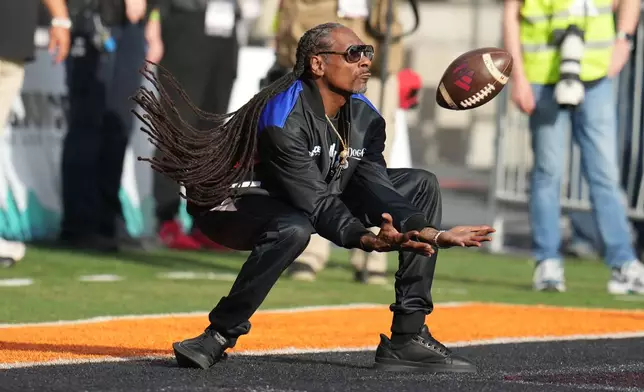 Snoop Dogg tries to make the catch on a kick off in the first half of the Snoop Dogg Arizona Bowl NCAA college football game between Fresno State and Miami, Saturday, Dec. 27, 2025, in Tucson, Ariz. (AP Photo/Rick Scuteri)
