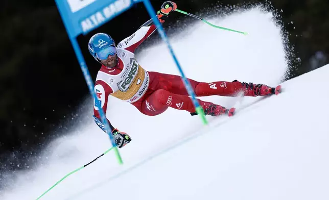 Austria's Marco Schwarz speeds down the course during an alpine ski, men's World Cup giant slalom, in Alta Badia, Italy, Sunday, Dec. 21,2025. (AP Photo/Gabriele Facciotti)
