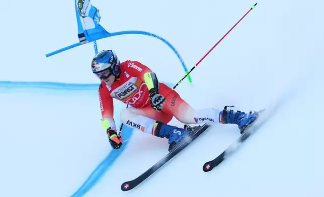 Switzerland's Marco Odermatt speeds down the course during an alpine ski, men's World Cup giant slalom, in Alta Badia, Italy, Sunday, Dec. 21,2025. (AP Photo/Alessandro Trovati)