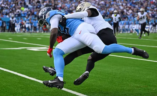 Tennessee Titans tight end Chig Okonkwo breaks away from New Orleans Saints cornerback Kool-Aid McKinstry on a touchdown reception in the first half of an NFL football game, Sunday, Dec. 28, 2025, in Nashville, Tenn. (AP Photo/John Amis)