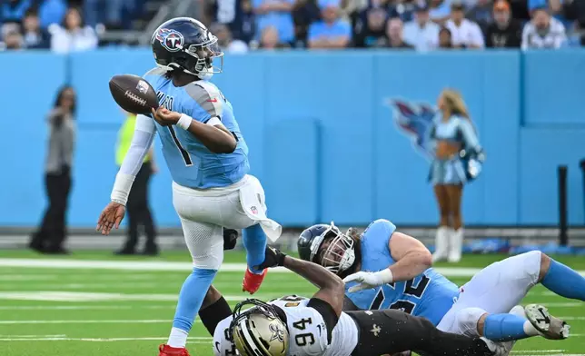 Tennessee Titans quarterback Cam Ward (1) is tripped up by New Orleans Saints defensive end Cameron Jordan (94) on the last play of the game, in the second half of an NFL football game, Sunday, Dec. 28, 2025, in Nashville, Tenn. (AP Photo/John Amis)