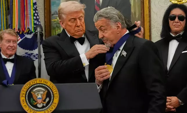 President Donald Trump, left, presents Sylvester Stallone with his Kennedy Center Honors medal in the Oval Office of the White House, Saturday, Dec. 6, 2025, in Washington. (AP Photo/Julia Demaree Nikhinson)
