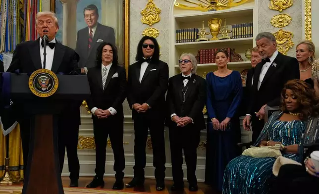 President Donald Trump, left, speaks as he presents Sylvester Stallone, George Strait, KISS, Gloria Gaynor and Michael Crawford with their Kennedy Center Honors medals in the Oval Office of the White House, Saturday, Dec. 6, 2025, in Washington. (AP Photo/Julia Demaree Nikhinson)