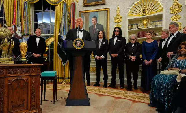 President Donald Trump, center, speaks as he presents Sylvester Stallone, George Strait, KISS, Gloria Gaynor and Michael Crawford with their Kennedy Center Honors medals in the Oval Office of the White House, Saturday, Dec. 6, 2025, in Washington. (AP Photo/Julia Demaree Nikhinson)