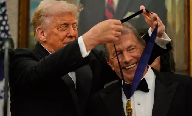 President Donald Trump, left, presents George Strait with his Kennedy Center Honors medal in the Oval Office of the White House, Saturday, Dec. 6, 2025, in Washington. (AP Photo/Julia Demaree Nikhinson)