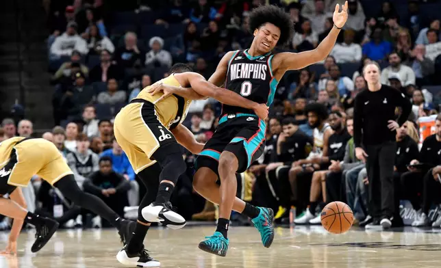 Washington Wizards guard CJ McCollum, center left, fouls Memphis Grizzlies forward Jaylen Wells (0) in the first half of an NBA basketball game Saturday, Dec. 20, 2025, in Memphis, Tenn. (AP Photo/Brandon Dill)