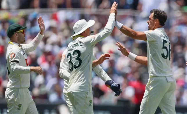 Australia's Mitchell Starc, right, celebrates the wicket of England's Jofra Archer with his teammates during play on the final day of the third Ashes cricket test between England and Australia in Adelaide, Australia, Sunday, Dec. 21, 2025. (AP Photo/James Elsby)