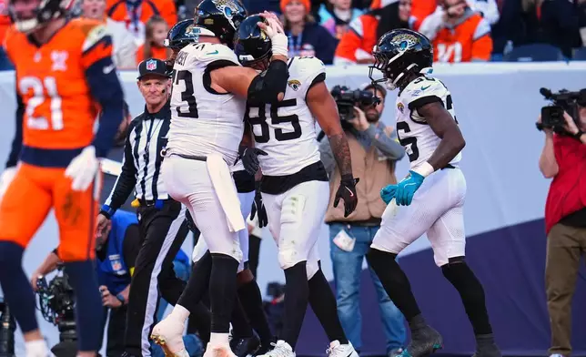 Jacksonville Jaguars tight end Brenton Strange (85) celebrates with center Robert Hainsey (73) after scoring a touchdown against the Denver Broncos during the first half of an NFL football game in Denver, Sunday, Dec. 21, 2025. (AP Photo/Jack Dempsey)