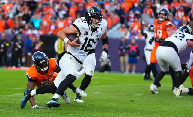 Jacksonville Jaguars quarterback Trevor Lawrence (16) runs with the ball during the second half of an NFL football game against the Denver Broncos in Denver, Sunday, Dec. 21, 2025. (AP Photo/Jack Dempsey)