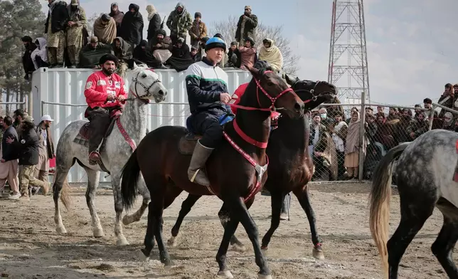Riders from the Sar-e-Pul and Badakhshan teams enter the field to compete in the final of Afghanistan's annual buzkashi tournament, a traditional equestrian sport in which riders score points using a fake goat carcass, on the outskirts of Kabul, Afghanistan, Monday, Dec. 22, 2025. (AP Photo)