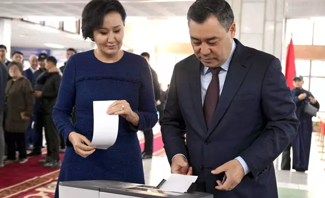 In this photo provided by Kyrgyzstan's Presidential Press Office, Kyrgyz President Sadyr Japarov and his wife Aigul Japarova vote during the parliamentary elections at a polling station, in Bishkek, Kyrgyzstan, Sunday, Nov. 30, 2025. (Sultan Dosaliev,Kyrgyzstan's Presidential Press Office via AP)