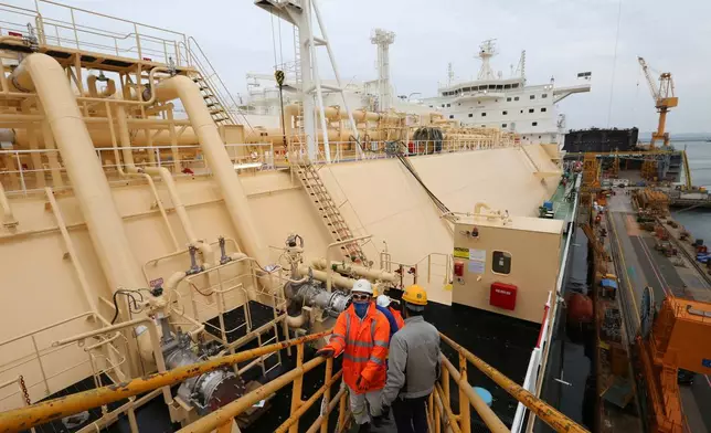 FILE - Workers board large-sized liquefied natural gas (LNG) carriers under construction at the Daewoo Shipbuilding and Marine Engineering facility in Geoje Island, South Korea, Dec. 7, 2018. (AP Photo/Ahn Young-joon, File)