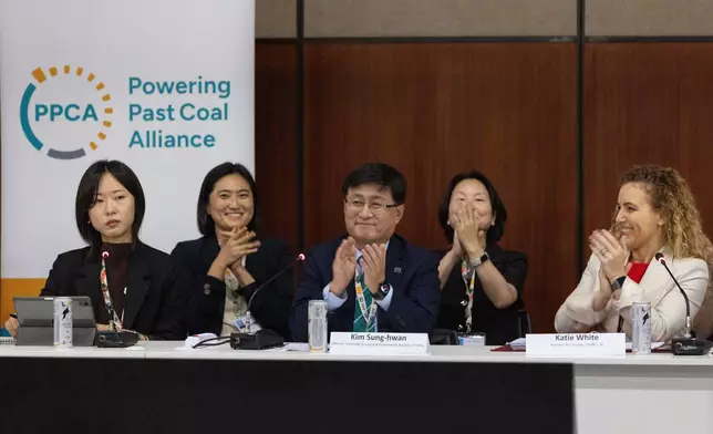 Kim Sung-hwan, center, the inaugural head of South Korea's new Ministry of Climate, Energy and Environment, applauds after he made the announcement of South Korea joining the Powering Past Coal Alliance, during U.N. climate talks in Belem, Brazil, Nov. 17, 2025. (AP Photo/Anton L. Delgado)