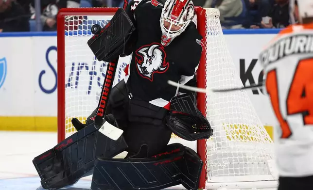 Buffalo Sabres goaltender Alex Lyon makes a save during the second period of an NHL hockey game against the Philadelphia Flyers, Thursday, Dec. 18, 2025, in Buffalo, N.Y. (AP Photo/Jeffrey T. Barnes)
