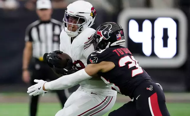 Houston Texans linebacker Henry To'Oto'O, right, tackles Arizona Cardinals tight end Pharaoh Brown during the first half of an NFL football game Sunday, Dec. 14, 2025, in Houston. (AP Photo/Ashley Landis)