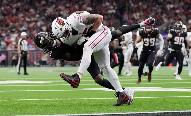 Arizona Cardinals tight end Trey McBride, right, is tackled by Houston Texans safety Calen Bullock (2) during the first half of an NFL football game Sunday, Dec. 14, 2025, in Houston. (AP Photo/Ashley Landis)