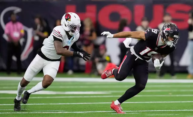 Houston Texans wide receiver Xavier Hutchinson (19) runs past Arizona Cardinals cornerback Will Johnson during the first half of an NFL football game Sunday, Dec. 14, 2025, in Houston. (AP Photo/Ashley Landis)