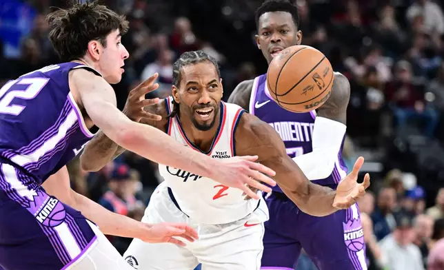 Los Angeles Clippers forward Kawhi Leonard (2) is fouled by by Sacramento Kings guard Dennis Schröder, right, as center Maxime Raynaud helps on defense in the second half of an NBA basketball game Tuesday, Dec. 30, 2025, in Inglewood, Calif. (AP Photo/Wally Skalij)