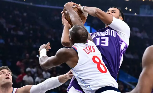 Sacramento Kings forward Keegan Murray (13) is fouled by Los Angeles Clippers guard Kris Dunn (8) in the first half of an NBA basketball game Tuesday, Dec. 30, 2025, in Inglewood, California. (AP Photo/Wally Skalij)
