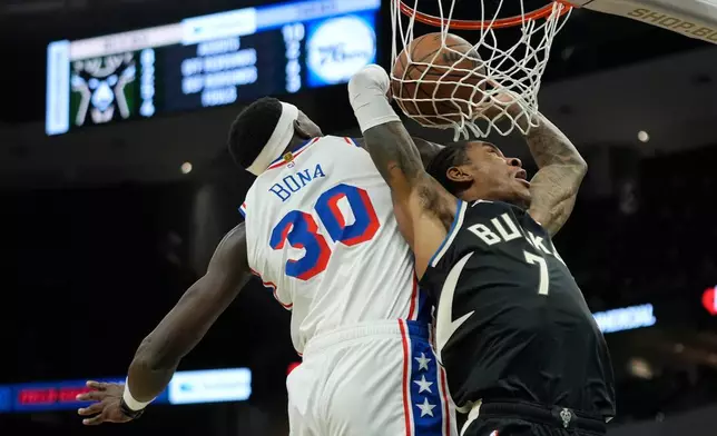 Milwaukee Bucks' Kevin Porter Jr. (7) dunks past Philadelphia 76ers' Adem Bona (30) during the first half of an NBA basketball game, Friday, Dec. 5, 2025, in Milwaukee. (AP Photo/Aaron Gash)