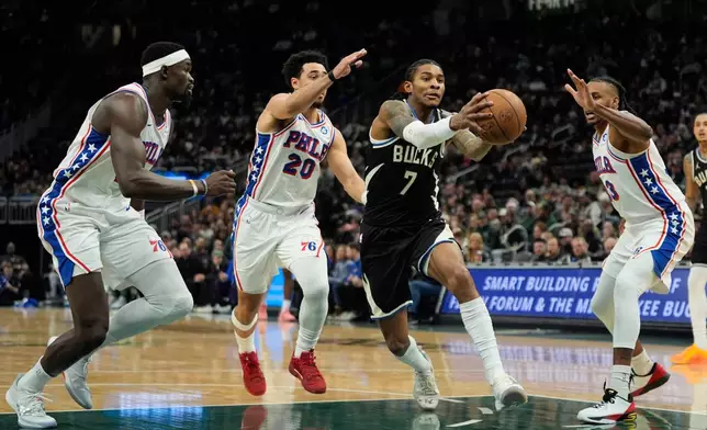 Milwaukee Bucks' Kevin Porter Jr. (7) drives to the basket against Philadelphia 76ers' Jabari Walker, right, Jared McCain (20), and Adem Bona during the first half of an NBA basketball game, Friday, Dec. 5, 2025, in Milwaukee. (AP Photo/Aaron Gash)