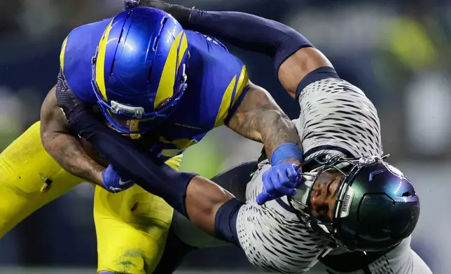Los Angeles Rams running back Kyren Williams, left, is brought down by Seattle Seahawks safety Nick Emmanwori during the first half of an NFL football game Thursday, Dec. 18, 2025, in Seattle. (AP Photo/John Froschauer)