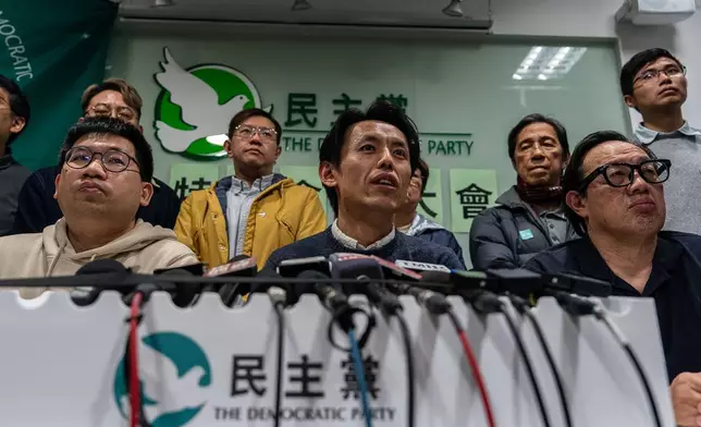 Lo Kin-hei, chairman of Hong Kong's Democratic Party, center, speaks at a press conference at the office of Hong Kong's Democratic Party in Hong Kong on Sunday, Dec. 14, 2025. (AP Photo/Chan Long Hei)
