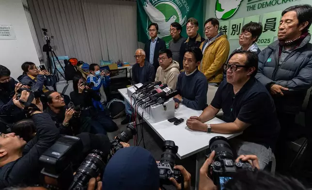 Lo Kin-hei, chairman of Hong Kong's Democratic Party, center, speaks at a press conference at the office of Hong Kong's Democratic Party in Hong Kong on Sunday, Dec. 14, 2025. (AP Photo/Chan Long Hei)