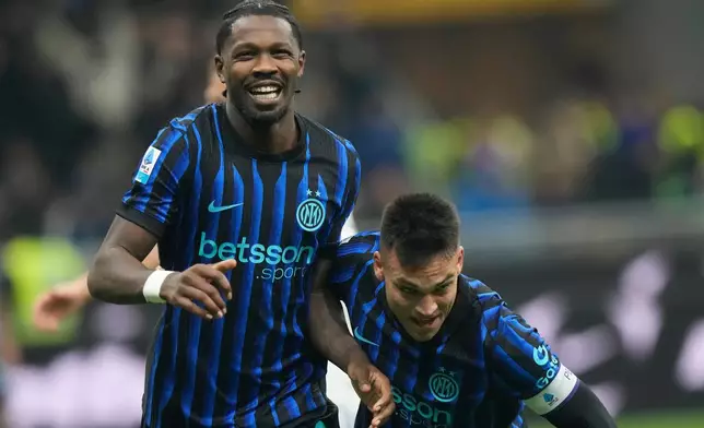 Inter Milan's Marcus Thuram, left, celebrates with his teammate Lautaro Martinez after scoring his side's second goal during a Serie A soccer match between Inter and Como, in Milan, Italy, Saturday, Dec. 6, 2025. (AP Photo/Luca Bruno)