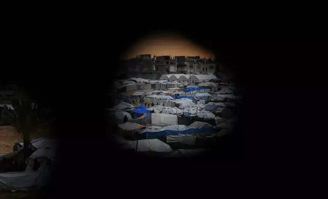 Seen from a building heavily damaged during the Israeli air and ground operations, tents fill a makeshift camp for displaced Palestinians in Deir al-Balah, central Gaza Strip, Saturday, Dec. 13, 2025. (AP Photo/Abdel Kareem Hana)