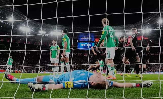 Newcastle's goalkeeper Nick Pope lies on the ground after Leverkusen scored their side's opening goal during the Champions League opening phase soccer match between Bayer Leverkusen and Newcastle United in Leverkusen, Germany, Wednesday, Dec. 10, 2025. (AP Photo/Martin Meissner)
