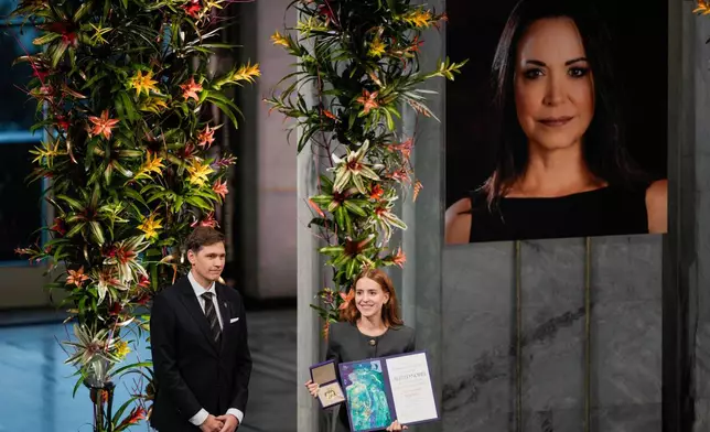 The daughter of the Nobel Peace Prize laureate, Ana Corina Sosa, accepts the award on behalf of her mother, Venezuelan opposition leader Maria Corina Machado, during the Nobel Peace Prize ceremony at Oslo City Hall, Norway, Wednesday Dec. 10, 2025. (Stian Lysberg Solum/NTB Scanpix via AP)