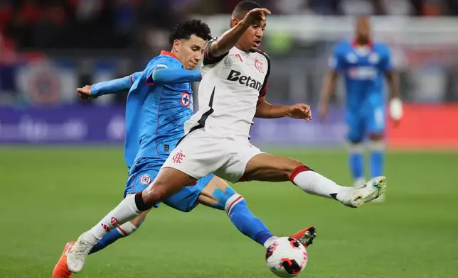 Flamengo's Samuel Lino, right, fights for the ball with Cruz Azul's Jorge Sanchez during the FIFA Intercontinental Cup soccer match between Cruz Azul and Flamengo in Doha, Qatar, Wednesday, Dec. 10, 2025. (AP Photo/Hussein Sayed)