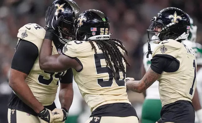 From left, New Orleans Saints defensive end Cameron Jordan, outside linebacker Demario Davis and cornerback Alontae Taylor (1) celebrate after a sack during the first half of an NFL football game against the New York Jets, Sunday, Dec. 21, 2025, in New Orleans. (AP Photo/Gerald Herbert)